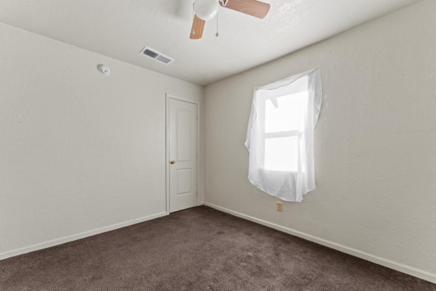 5192 Chestnut Road Olivehurst, CA 95961 - Photo 13 of 24 an empty room with a window and a ceiling fan
