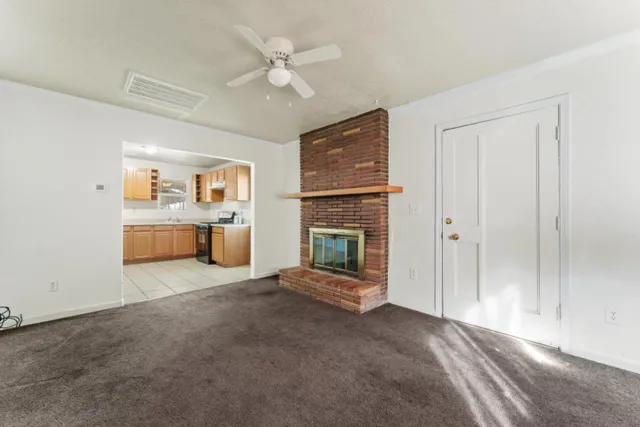 a view of a livingroom with a fireplace a sink and dishwasher kitchen view