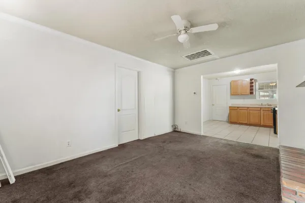 a view of an empty room with a ceiling fan