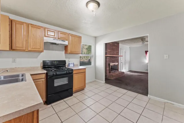 a kitchen with stainless steel appliances granite countertop a stove a sink and a refrigerator