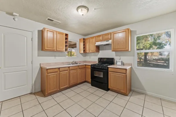 a kitchen with granite countertop a sink and a stove top oven