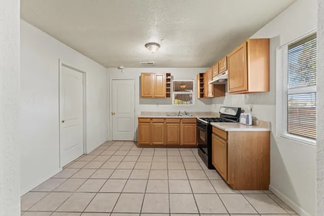 a kitchen with a stove top oven sink and cabinets