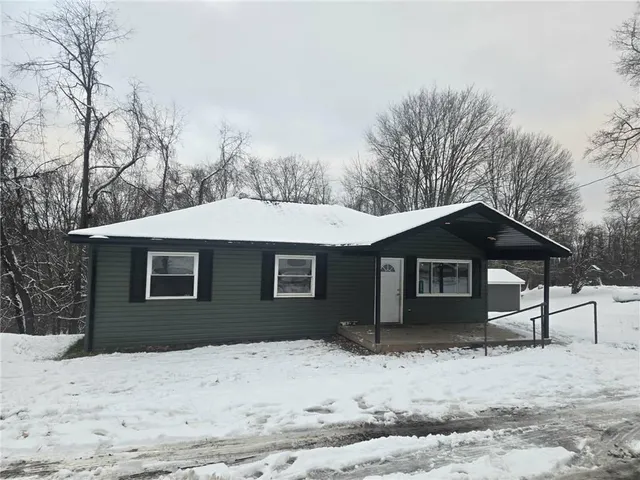 a front view of a house with a yard covered in snow