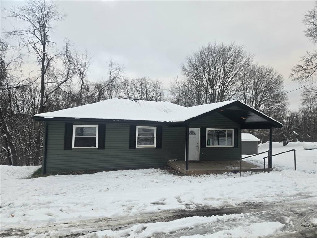 a front view of a house with a yard covered in snow
