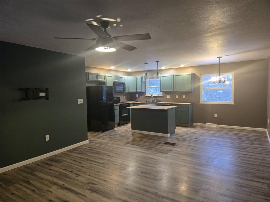 504 Queenstown Road Karns City, PA 16041 - Photo 2 of 18 an empty room with wooden floor kitchen view and a window