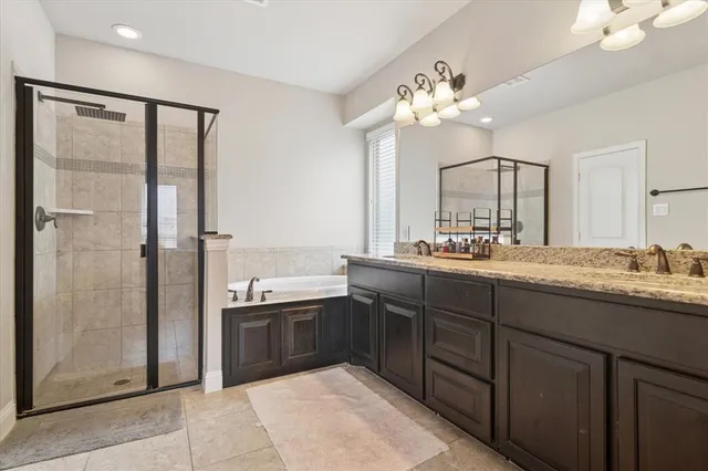a bathroom with a granite countertop sink a large mirror and a shower