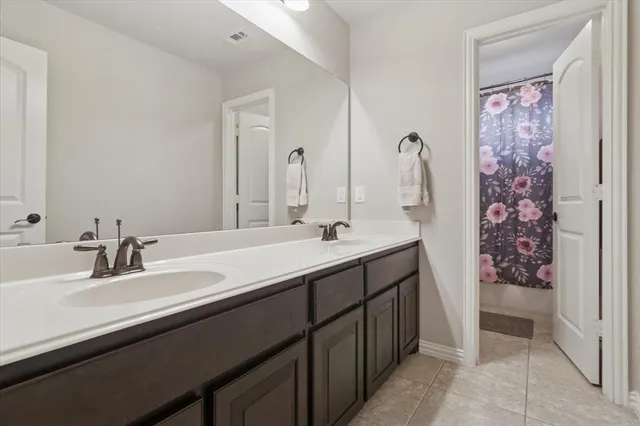 a bathroom with a double vanity sink and a mirror