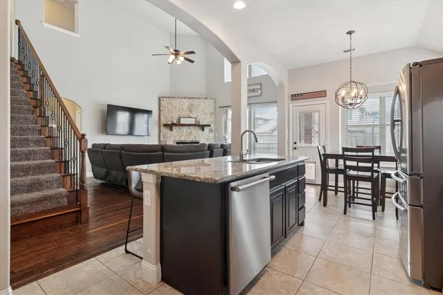 a kitchen with kitchen island granite countertop a sink and a stove