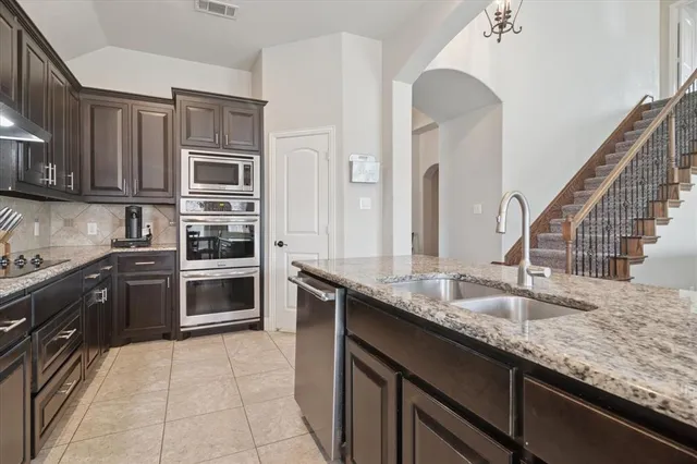 a kitchen with stainless steel appliances granite countertop a sink and stove