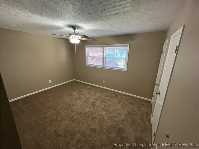 en empty room with windows and fan