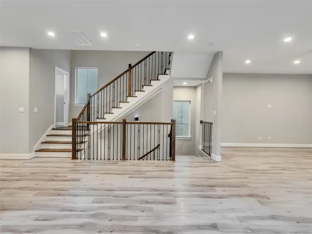 an empty room with wooden floor and entryway