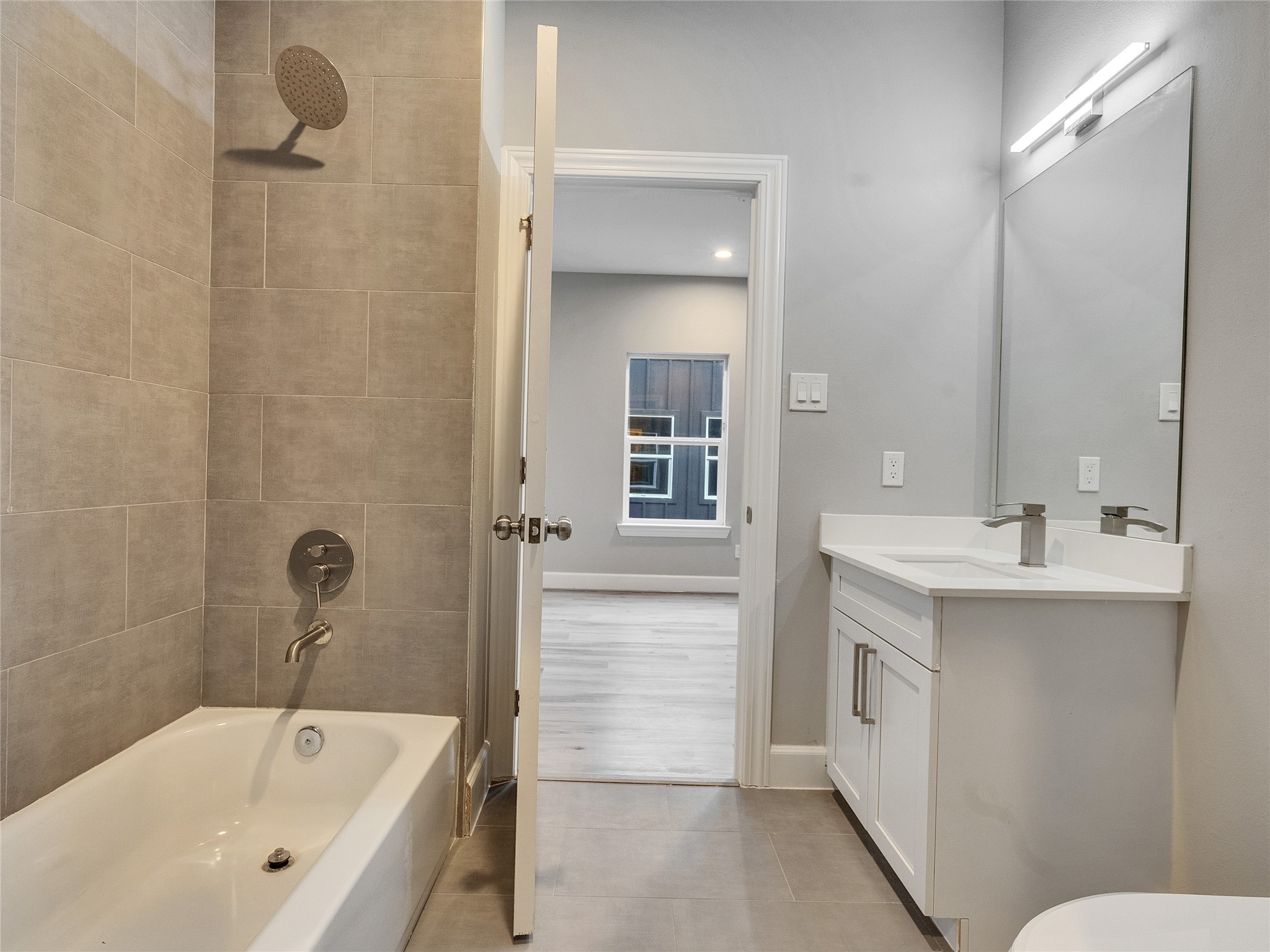 1122 West 16th Street, Unit D Houston, TX 77008 - Photo 29 of 40 a bathroom with a bathtub sink and mirror