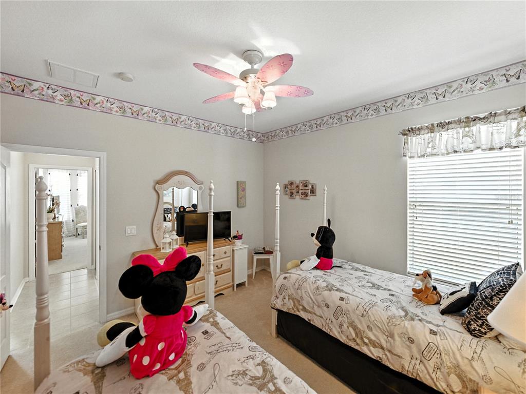 2530 Cross More Street Valrico, FL 33594 - Photo 17 of 61 a bedroom with a bed potted plant on the dresser and a chandelier
