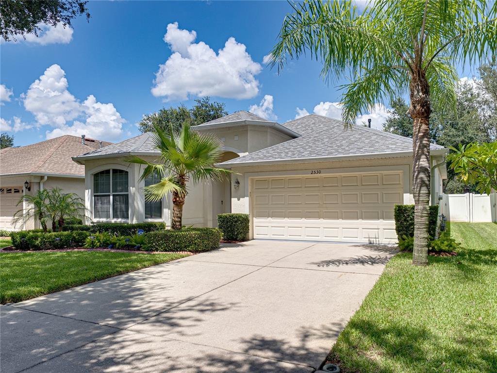 2530 Cross More Street Valrico, FL 33594 - Photo 4 of 61 a front view of a house with a garden and a yard