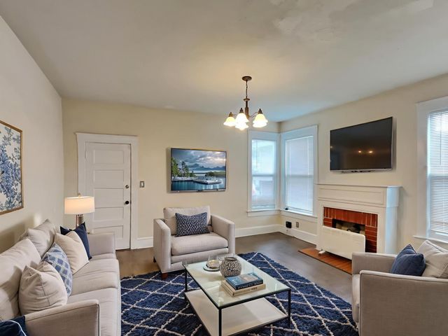 a living room with furniture a fireplace and a flat screen tv