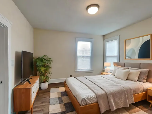 a bedroom with a bed and a flat screen tv