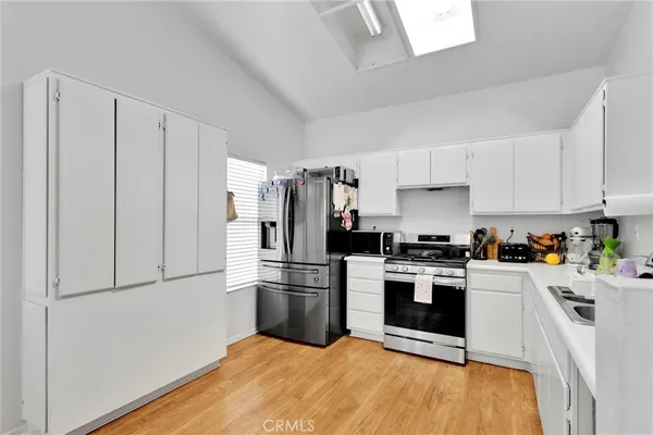 a kitchen with stainless steel appliances a refrigerator stove and white cabinets
