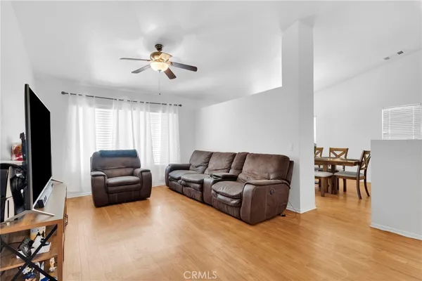 a living room with furniture a dining table and a flat screen tv with wooden floor