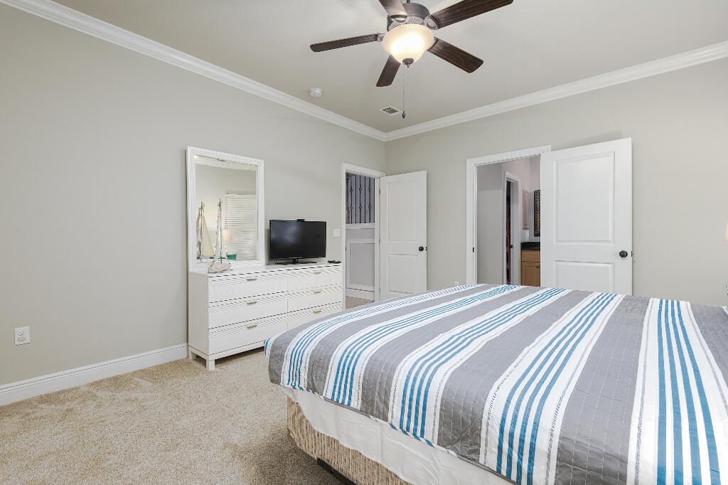 202 Kono Way Destin, FL 32541 - Photo 13 of 29 a bedroom with a large bed and a chandelier