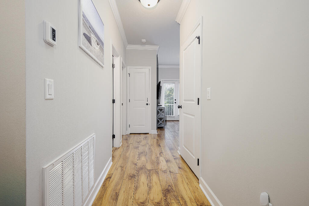 202 Kono Way Destin, FL 32541 - Photo 14 of 29 a view of a hallway with wooden floor and a bathroom