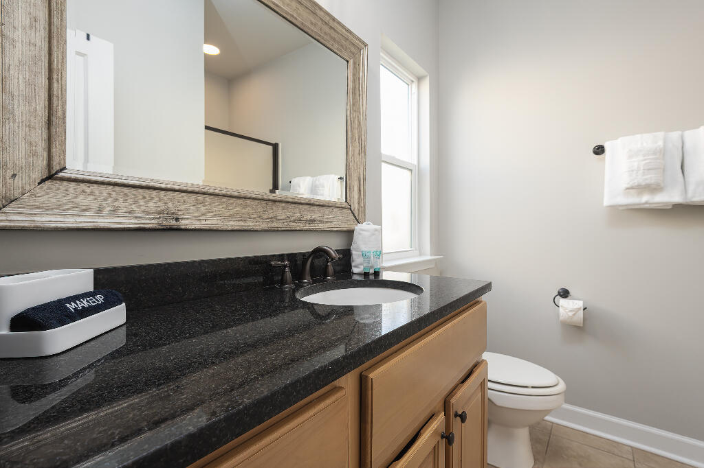 202 Kono Way Destin, FL 32541 - Photo 25 of 29 a bathroom with a granite countertop sink a toilet and mirror