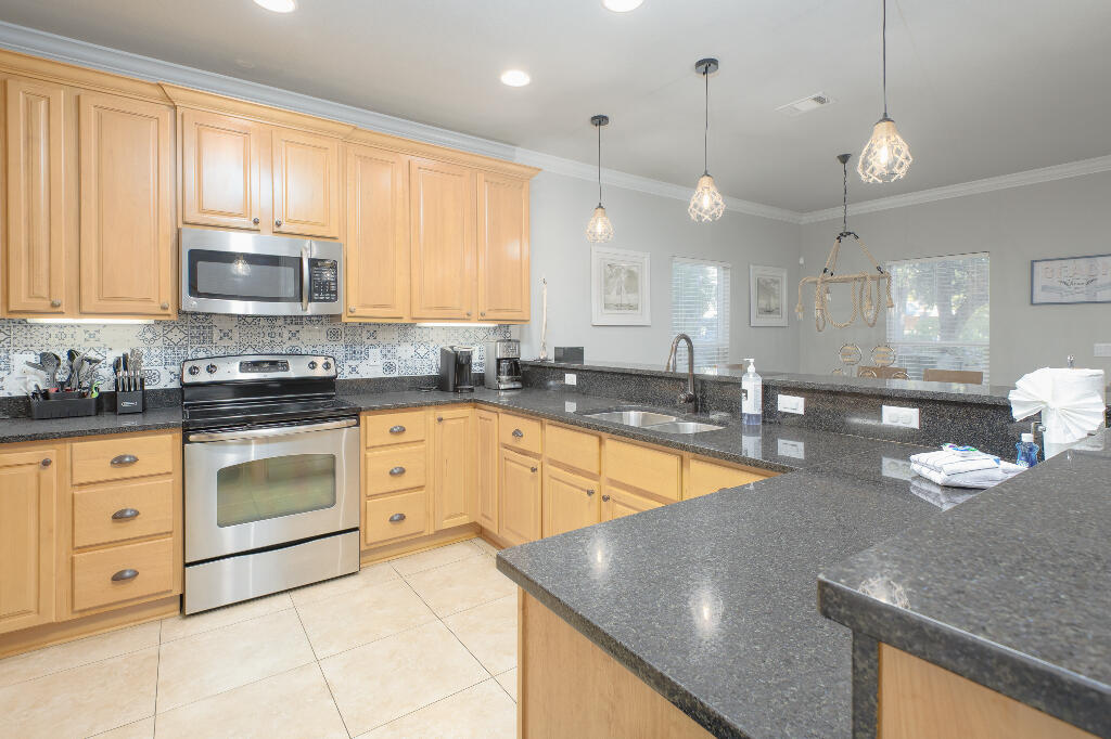 202 Kono Way Destin, FL 32541 - Photo 5 of 29 a kitchen with stainless steel appliances granite countertop a sink a stove and a granite counter tops