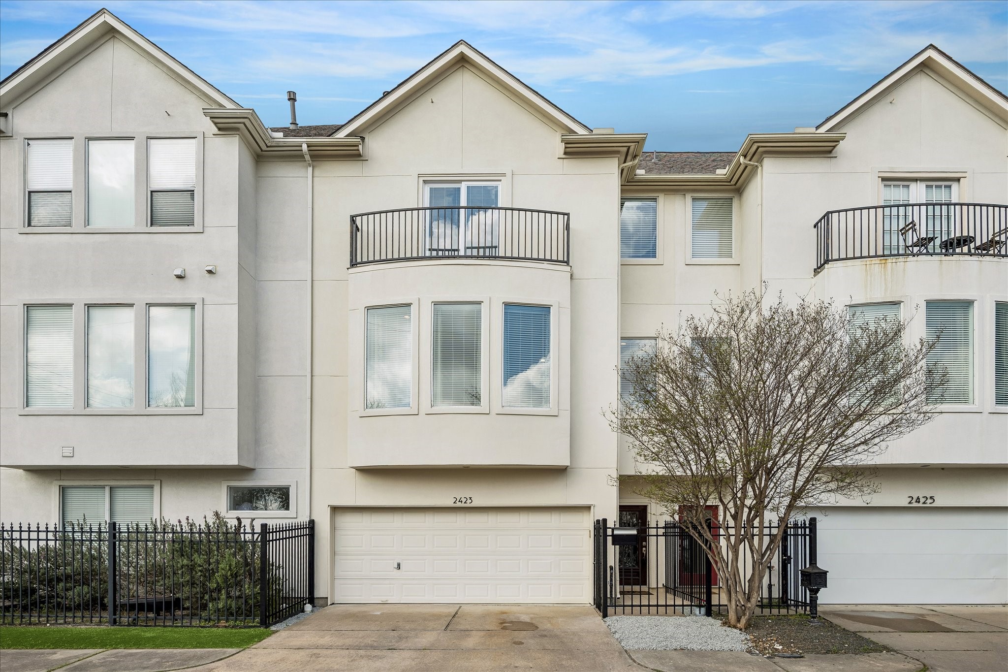 a view of a white house with large windows and a tree