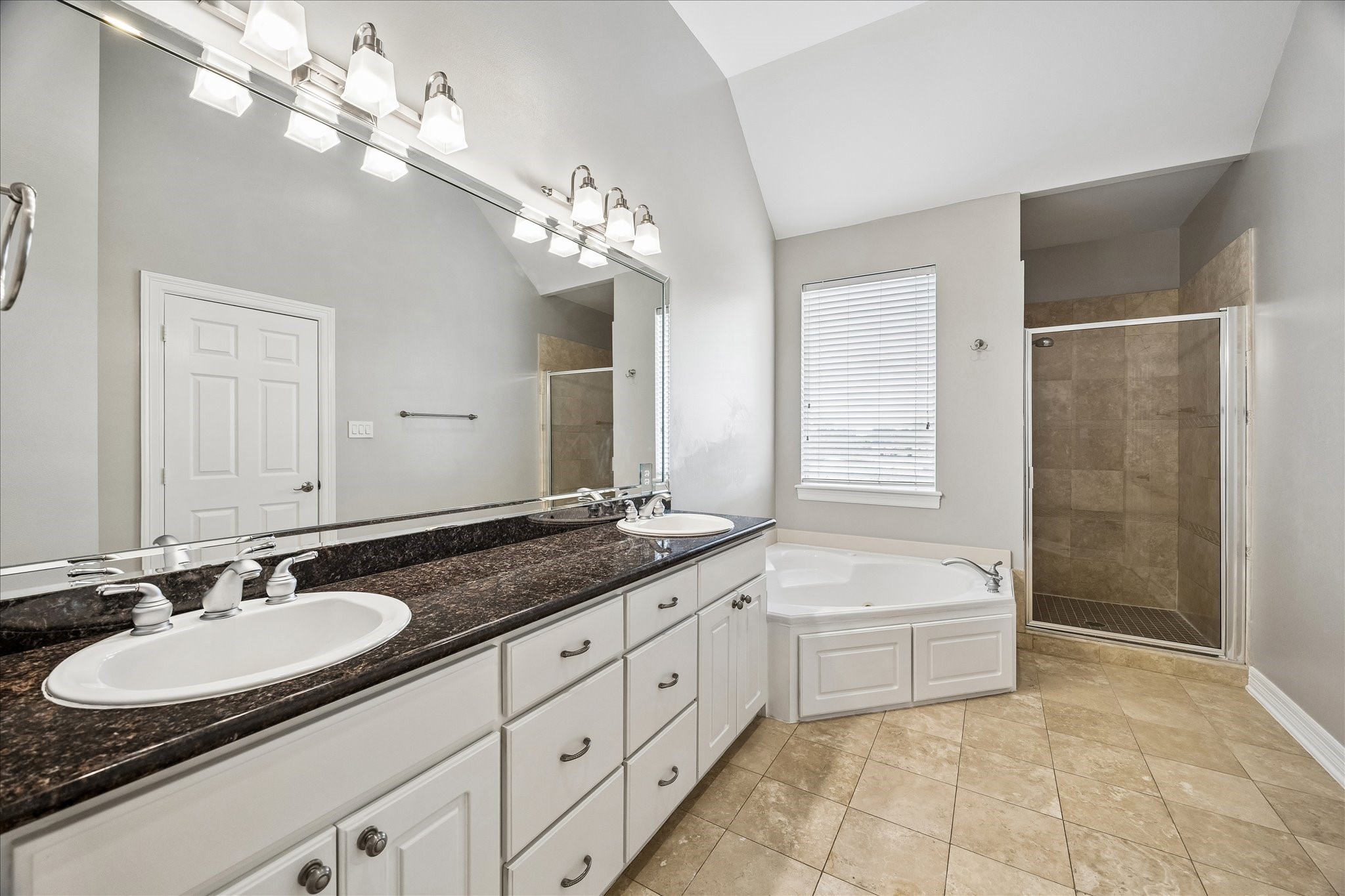2423 Ralph Street Houston, TX 77006 - Photo 17 of 24 a spacious bathroom with a granite countertop double vanity sink a mirror a bathtub and window
