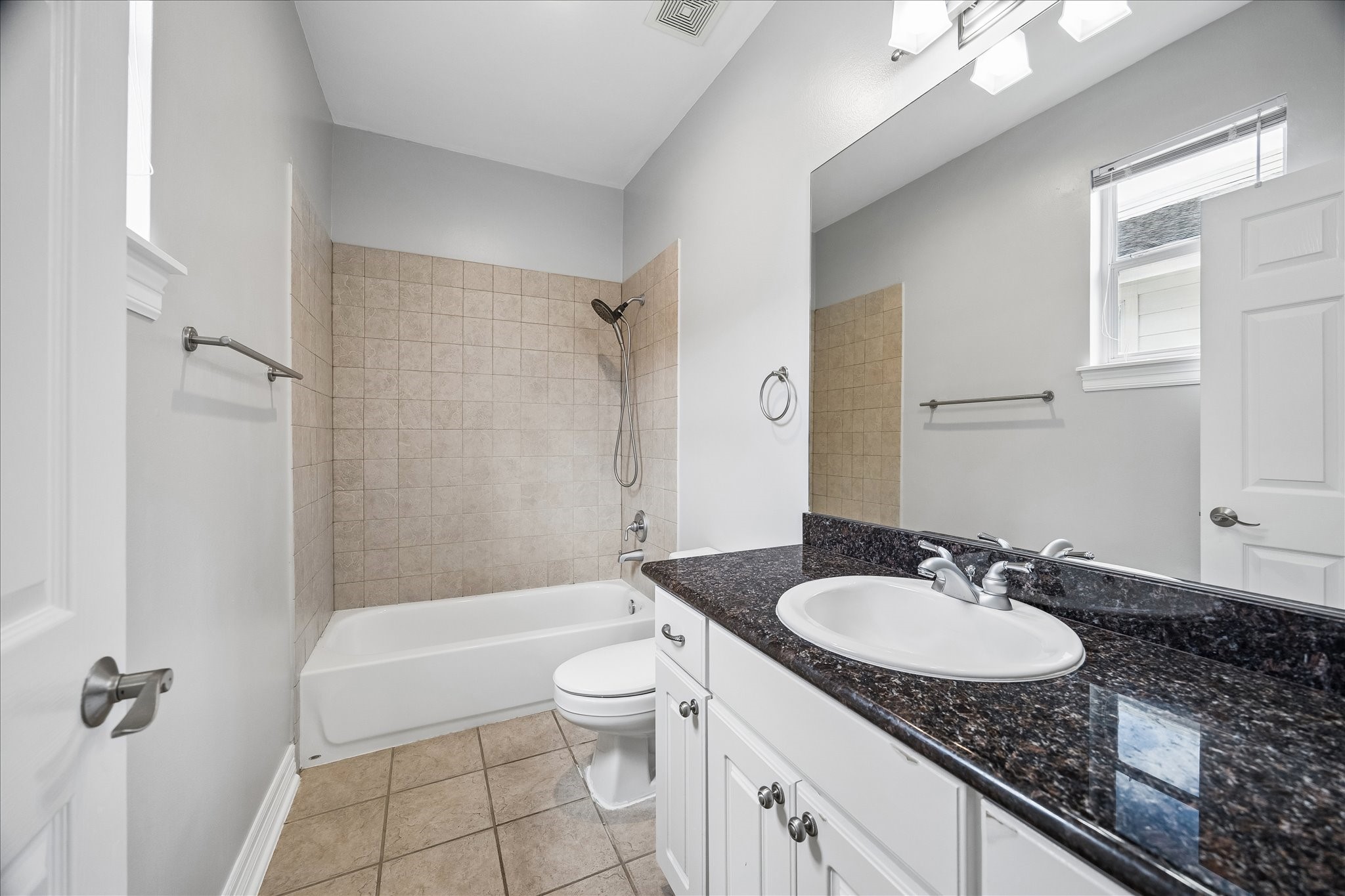 2423 Ralph Street Houston, TX 77006 - Photo 20 of 24 a bathroom with a granite countertop sink a mirror a toilet and bathtub