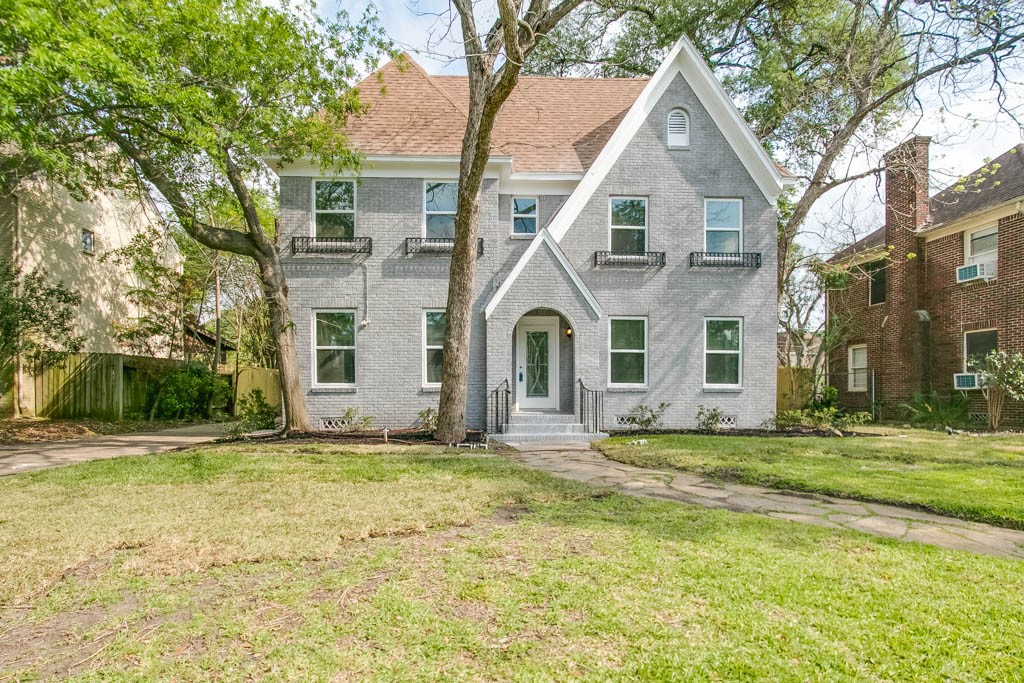 a view of a white house with a big yard and large trees