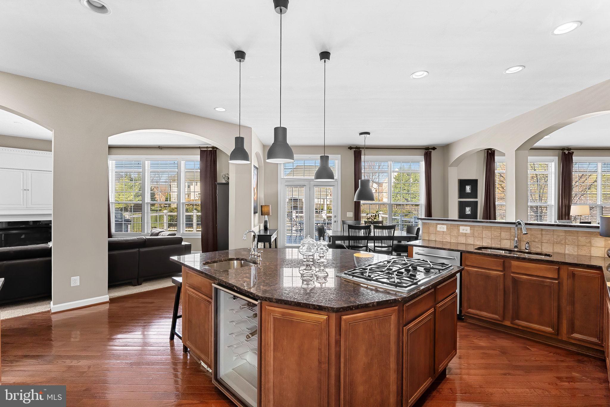 22461 Terra Rosa Place Ashburn, VA 20148 - Photo 13 of 67 a kitchen with stainless steel appliances granite countertop a sink a stove and a wooden floors