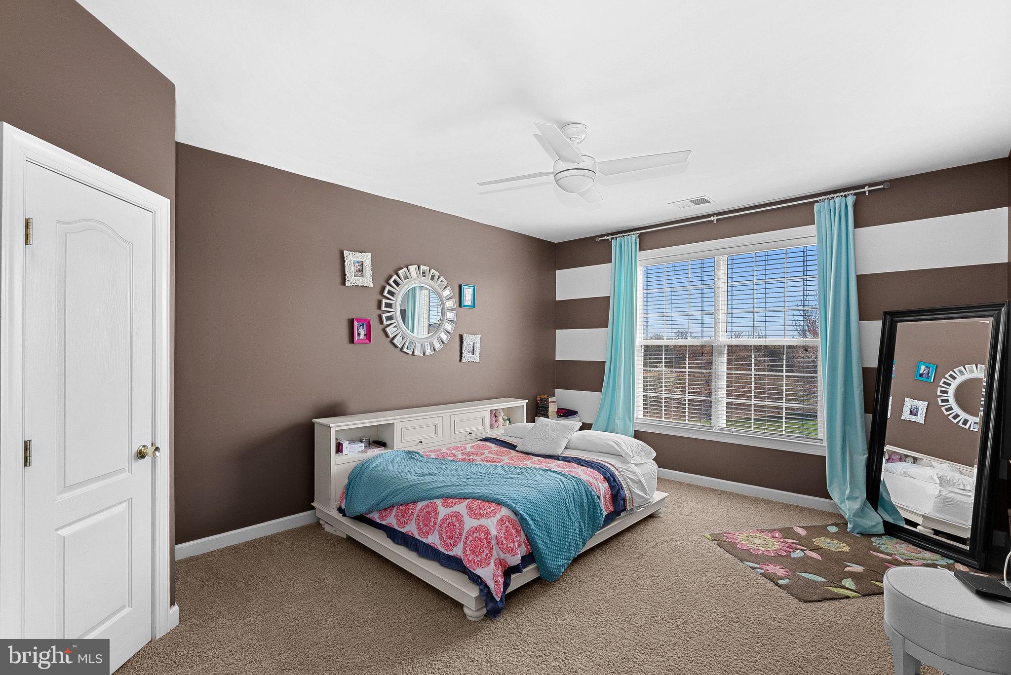 22461 Terra Rosa Place Ashburn, VA 20148 - Photo 30 of 67 a bedroom with a bed a dresser next to a window