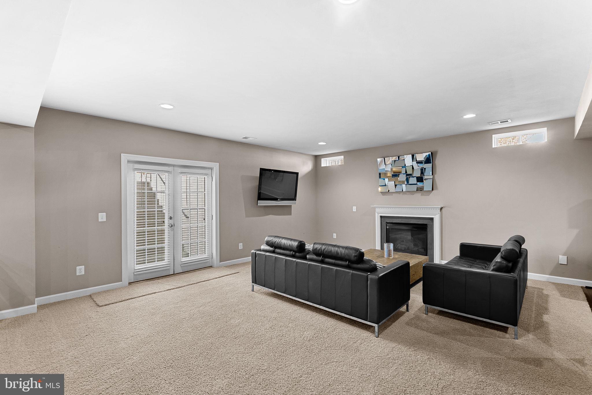 22461 Terra Rosa Place Ashburn, VA 20148 - Photo 45 of 67 a living room with furniture a fireplace and a flat screen tv