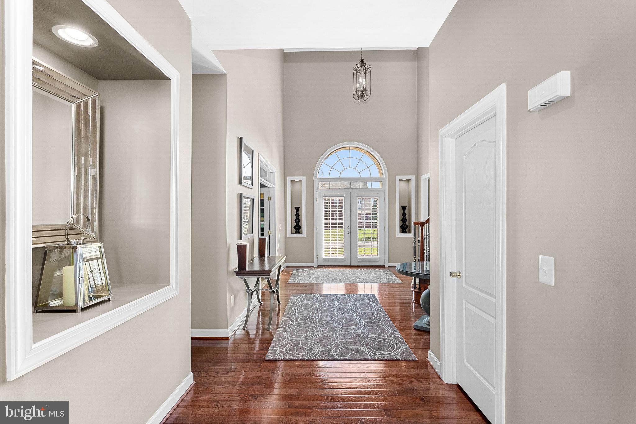 22461 Terra Rosa Place Ashburn, VA 20148 - Photo 6 of 67 a view of a hallway with wooden floor and a living room