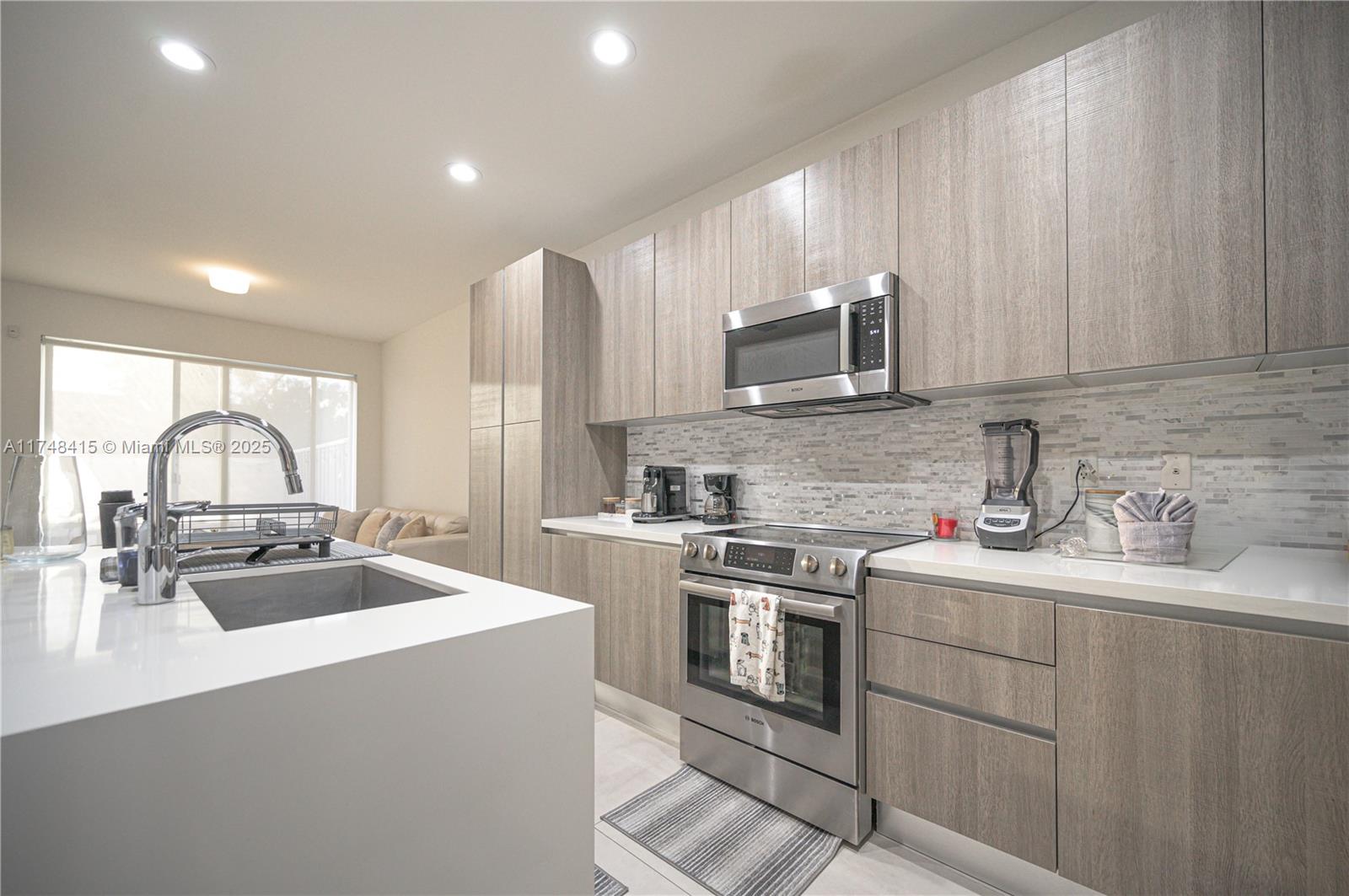 7250 Northwest 103rd Path Doral, FL 33178 - Photo 19 of 28 a kitchen with stainless steel appliances a sink stove and cabinets