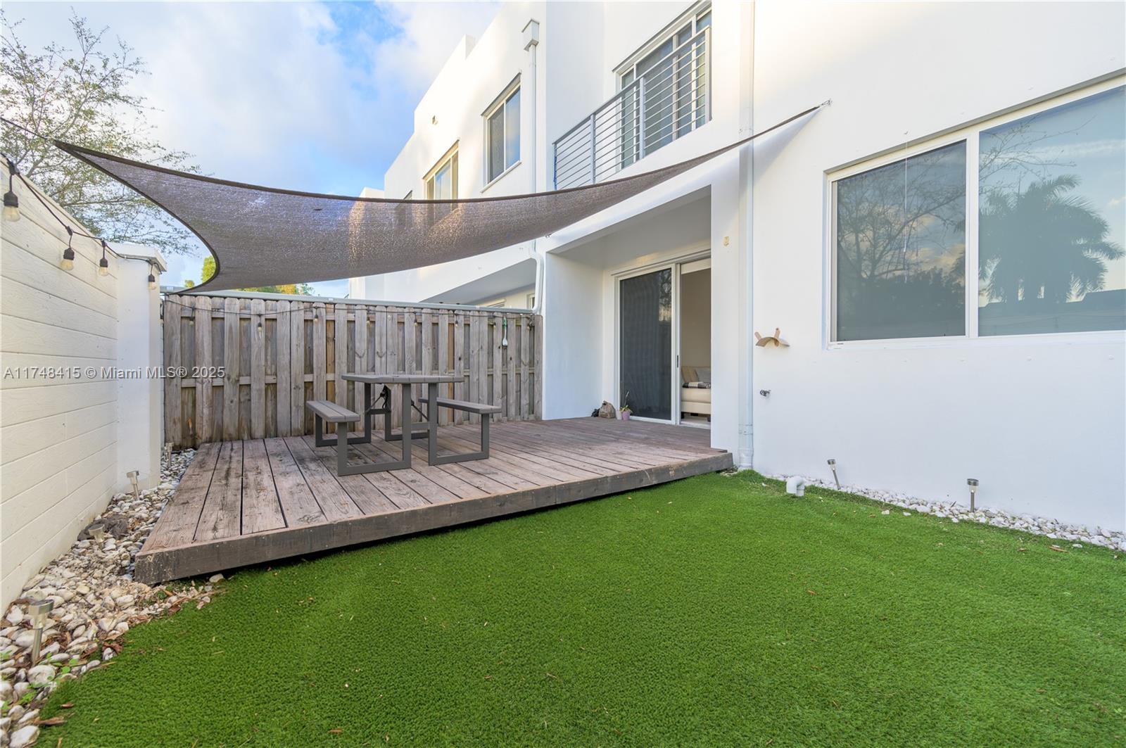 7250 Northwest 103rd Path Doral, FL 33178 - Photo 9 of 28 a view of a patio with table and chairs with wooden floor and fence