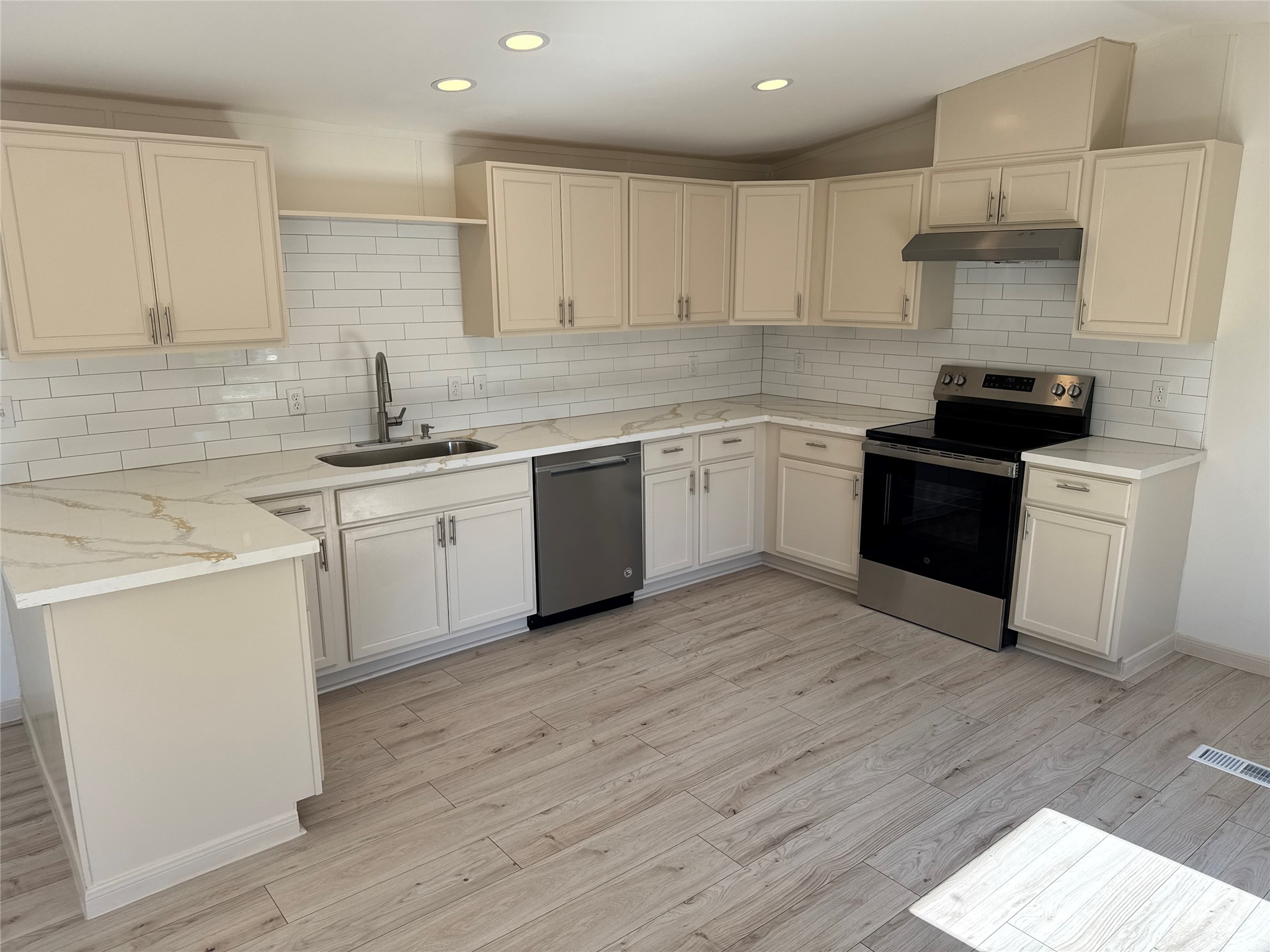 a kitchen with a sink a stove and cabinets