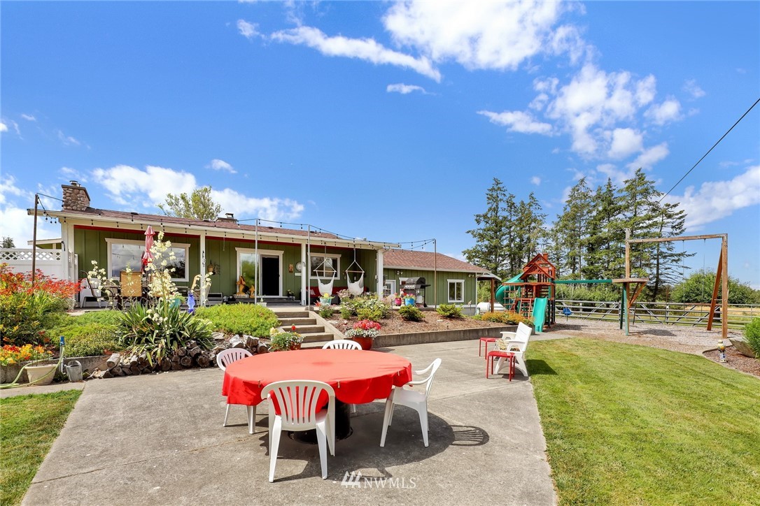 1468 East Smith Road Bellingham, WA 98226 - Photo 31 of 40 a view of a patio with table and chairs potted plants and a palm tree