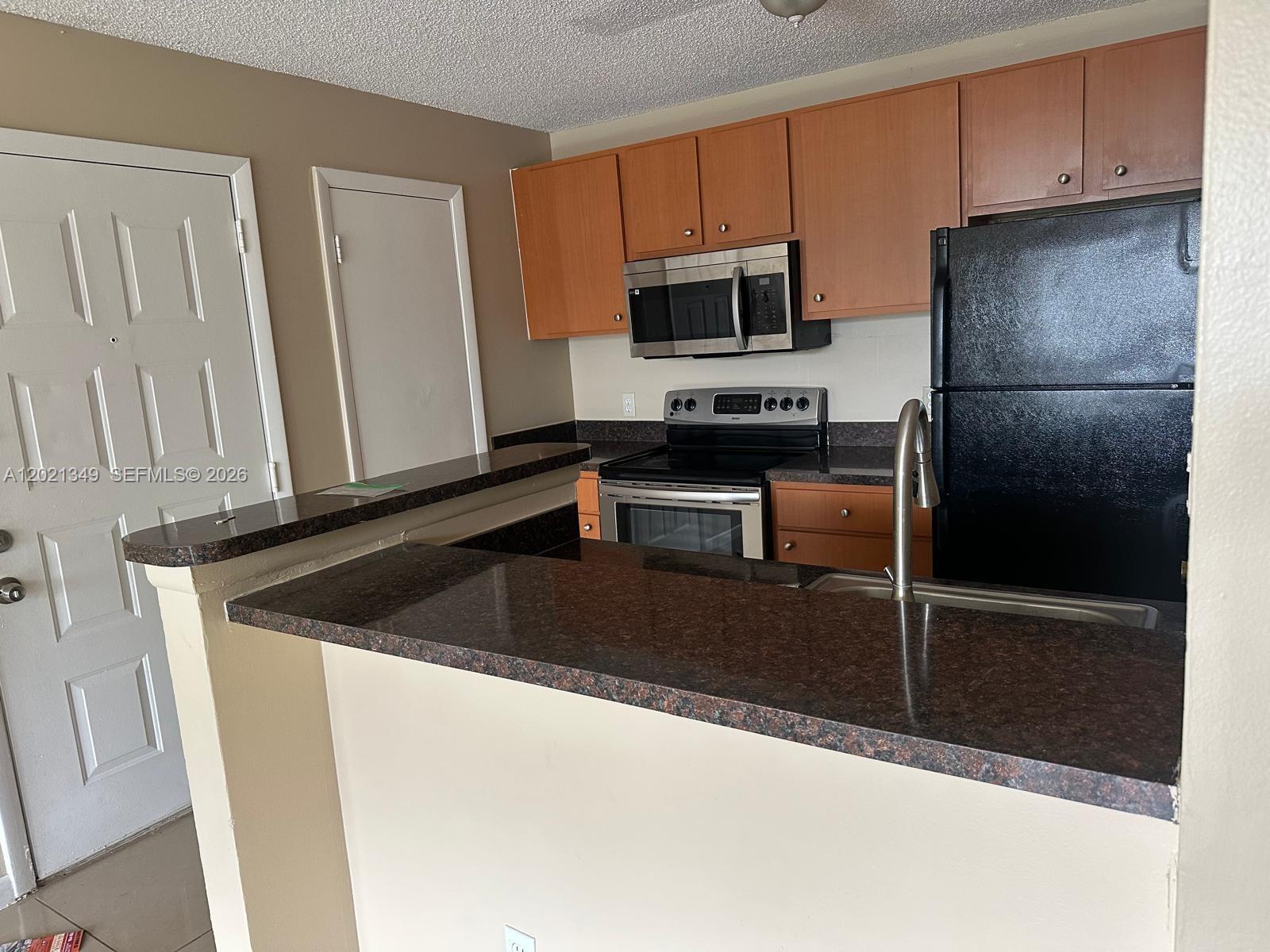 4481 West McNab Road, Unit 37 Pompano Beach, FL 33069 - Photo 9 of 20 a kitchen with a sink and a refrigerator