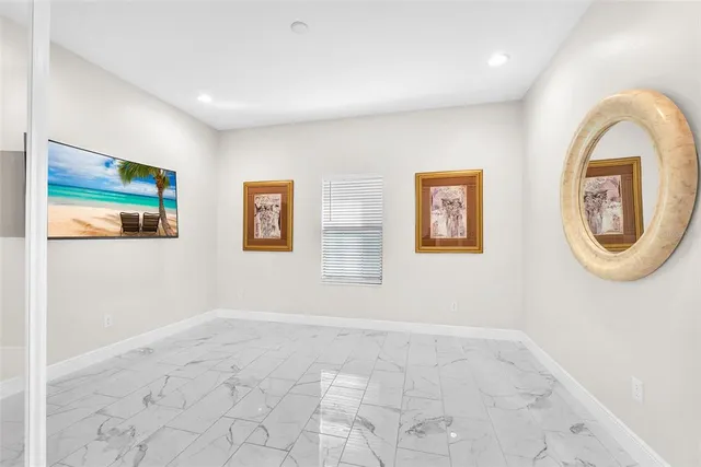 a view of a bedroom with wooden floor and window