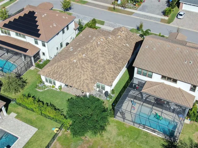 an aerial view of residential houses with outdoor space and parking