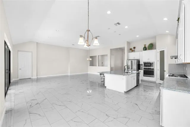 a large white kitchen with cabinets