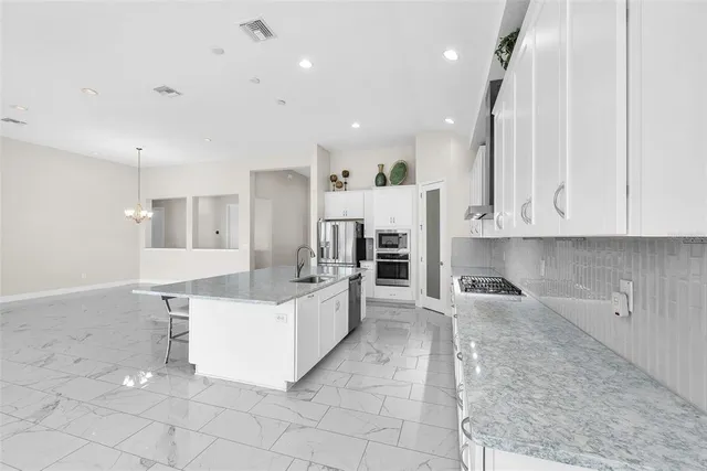 a large white kitchen with cabinets