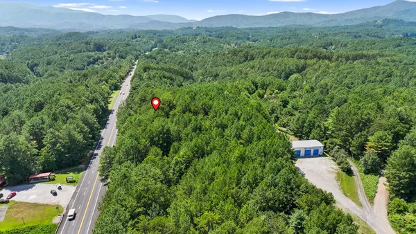 a aerial view of a house with a yard and mountain