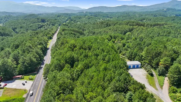 a aerial view of a house with a yard and mountain