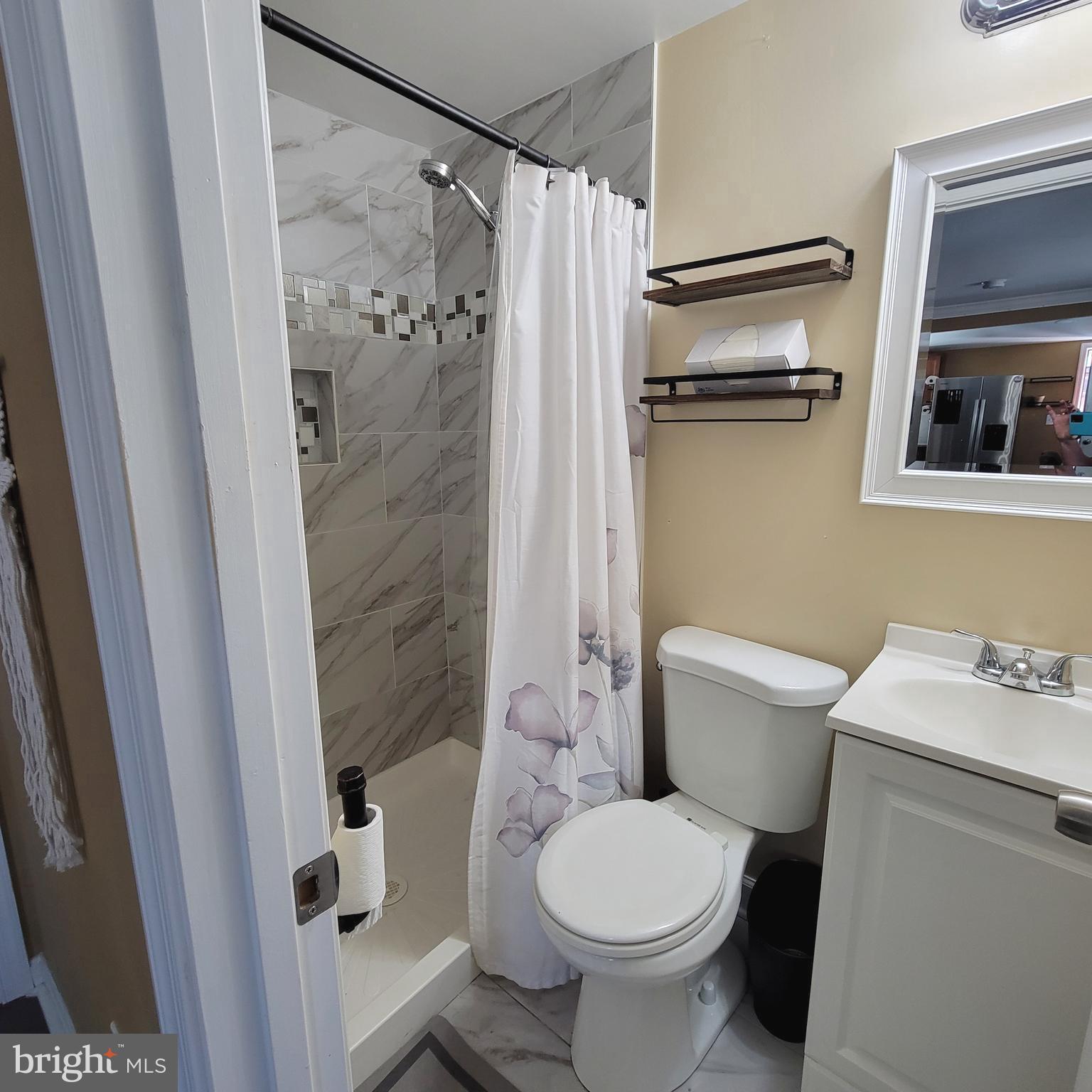 4715 Frederick Avenue Shady Side, MD 20764 - Photo 9 of 20 a white toilet sitting next to a shower curtain