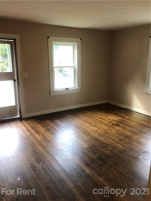 1020 Rodey Avenue, Unit A Charlotte, NC 28206 - Photo 2 of 8 an empty room with wooden floor and windows