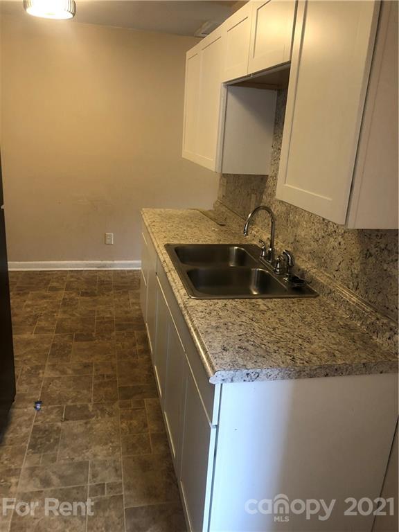 1020 Rodey Avenue, Unit A Charlotte, NC 28206 - Photo 4 of 8 a bathroom with a granite countertop sink a mirror and vanity