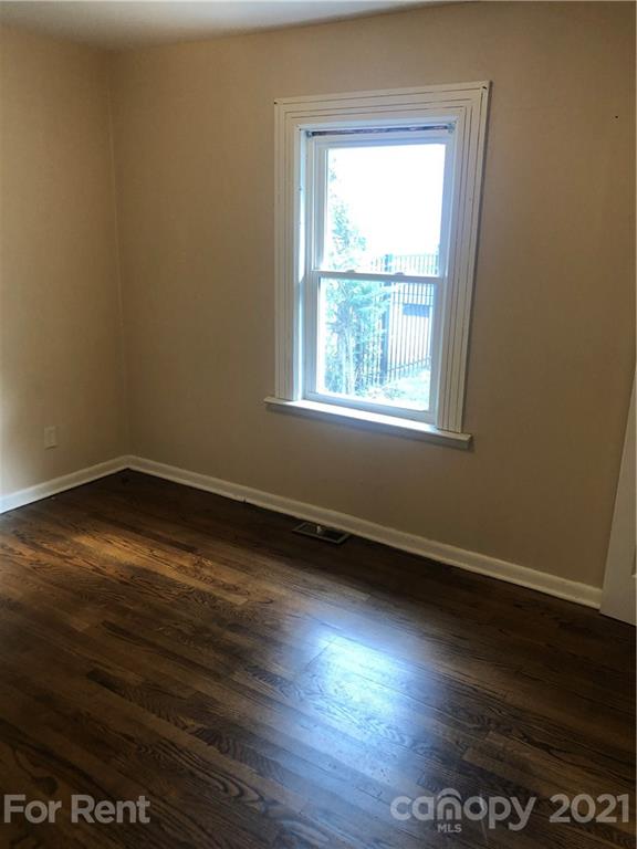 1020 Rodey Avenue, Unit A Charlotte, NC 28206 - Photo 5 of 8 an empty room with wooden floor and windows