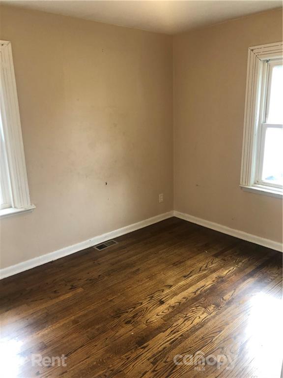 1020 Rodey Avenue, Unit A Charlotte, NC 28206 - Photo 6 of 8 an empty room with wooden floor and windows